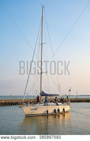 Nida, Lithuania - September 2020: White Sailboat On The Lagoon In Nida, Lithuania, Vertical