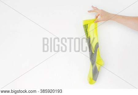Smelly yellow running sports sock in hand on light background