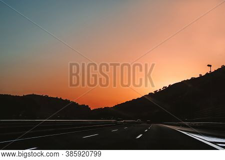 Roadtrip. Beautiful Sunrise With Pink And Blue Clean Sky On Highway With Smooth Road And Cars Drivin