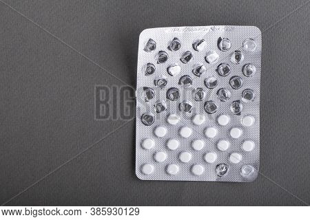 Started White Pills In Blister On Gray Background. Health Concept. Space For Text. Top View.