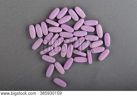 Heap Of Pink Medical Pills On A Gray Background. Health Concept. Top View.
