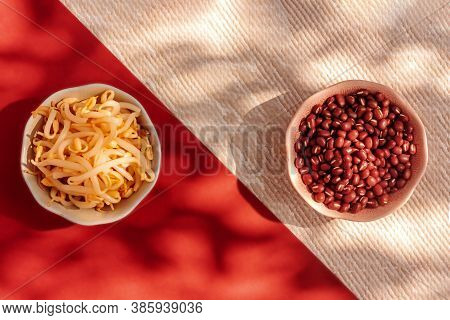 Red Mung Beans And Beansprouts In The Bowls On Red Background. Healthy Eating, Vegan Food Concept. T