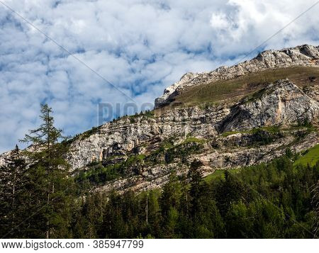 Terrible Lifeless Rocks, A Glacier In The Alps, Clouds And Fog Spread Over The Peaks Of The Mountain