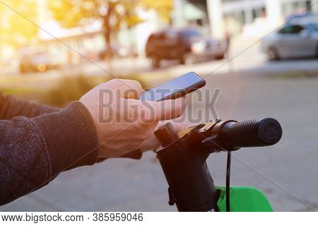 Close Up Image Of A Man On An Electric Scooter Paying Online By Mobile Phone