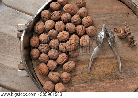 Walnuts And Nutcracker In A Round Silver Platter. View From Above.nutcracker And Nuts.walnut On Wood