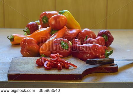 Slicing Pepper For Making Piccalilli. Sweet Peppers, Whole And Chopped.