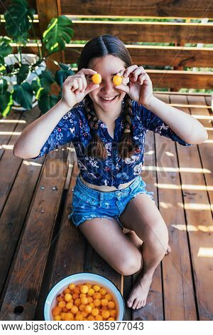 Young Girl Holding Yellow Fruits In Her Hands, Healthy Breakfast, Snack. Selective Focus