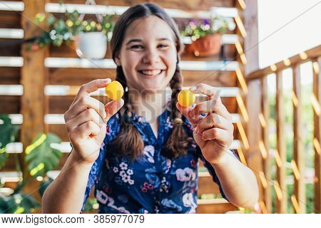 Young Girl Holding Yellow Fruits In Her Hands, Healthy Breakfast, Snack. Selective Focus