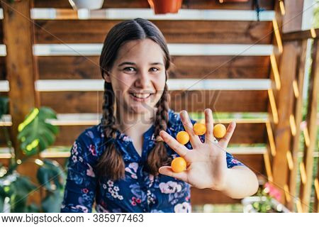 Young Girl Holding Yellow Fruits In Her Hands, Healthy Breakfast, Snack. Selective Focus