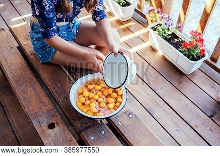 Girl Washes Yellow Fruits With Her Hands In A Bowl Of Water. Healthy Eating, Traditional Lifestyle.