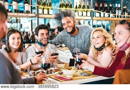 Friends Drinking Red Wine At Sushi Bar Restaurant With Open Face Masks - New Normal Lifestyle Concep