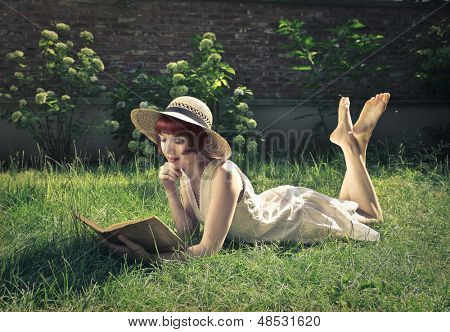 belle femme lisant un livre dans le jardin