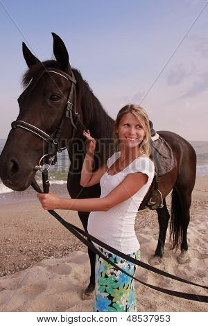Pige med en hest ved havet