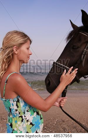 Pige med en hest ved havet