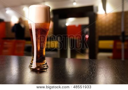bicchiere di birra lager fresca sul tavolo nel pub