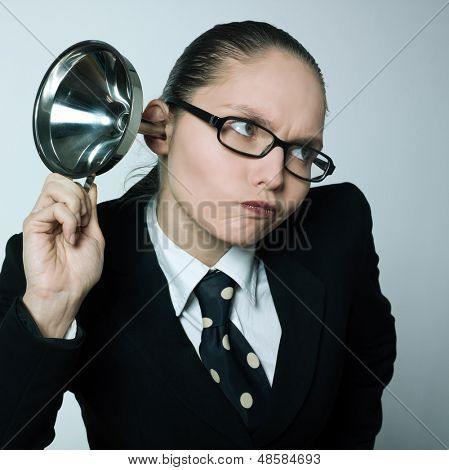 studio shot portrait of one caucasian curious business woman  hearing aid funnel curious spying gossip