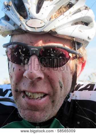 Cyclocross racer with mud in his teeth