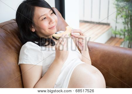 Pregnant woman eating melon