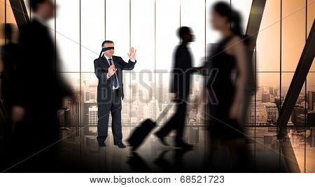 Mature businessman in a blindfold against busy room with large window looking on city
