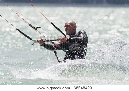Professional  Kitesurfer Jumps Over The Water During Training On Lake Of Santa Croce