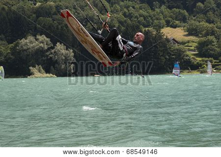 Professional  Kitesurfer Jumps Over The Water During Training On Lake Of Santa Croce