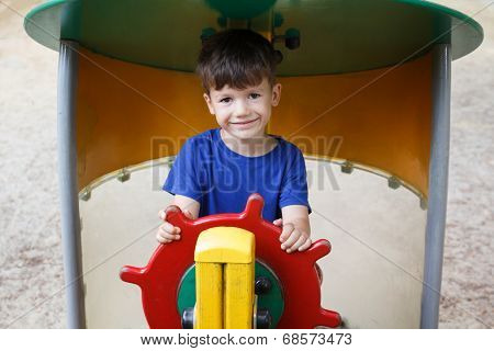 Little Boy As Helmsman On Playground