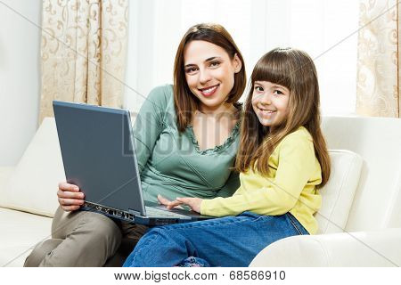 Mother and daughter using laptop