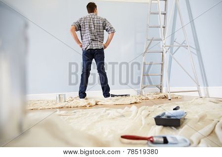 Man Decorating Nursery For New Baby