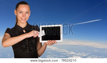 Beautiful businesswoman holding tablet PC and business card in front of screen. Blue sky with clowds