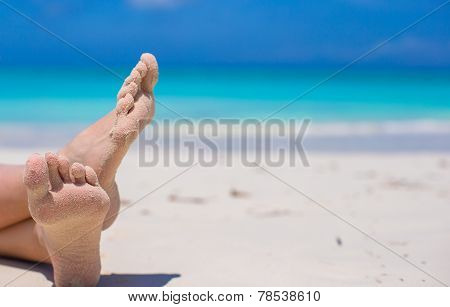 Close up of female feet on white sandy beach