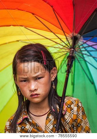 SAPA, VIETNAM - JUNE 10, 2011: Unidentified vietnamese girl with umbrella in Ta Van village. Though Vietnam's economic growth rate is among the highest in the world, poverty rate is still high