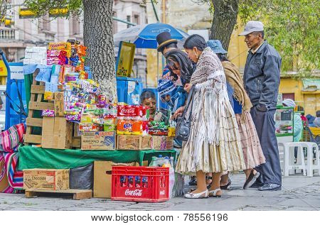 LA PAZ, BOLIVIA, MAY 9, 2014:  Local people buy sweets at street stand at Plaza Murillo
