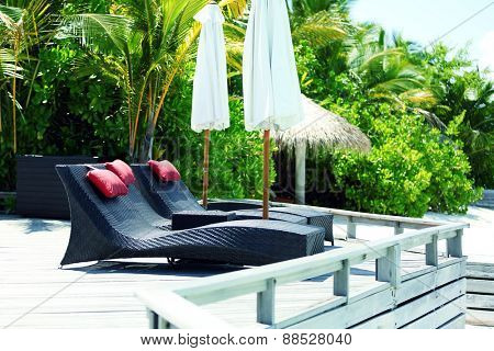 Sunbed in resort in hotel room over blue ocean in Baros Maldives