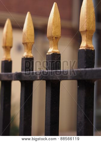 Golden colored iron fence pole tips