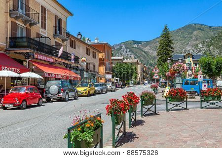 TENDE, FRANCE - AUGUST 12, 2014: Restaurants and bars along narrow road through Tende - small tourist town in French Alps, located on old route of salt trade and known for its cheese, honey and jams.