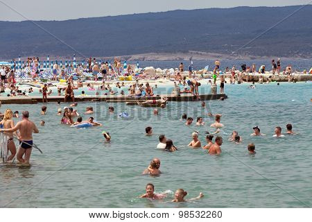 SELCE, CROATIA - JULY 24, 2015: People swimming and sunbathing on the Selce beach