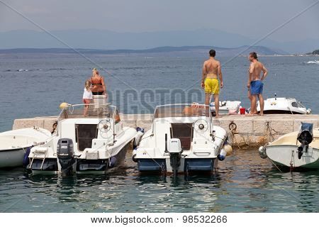 SELCE, CROATIA - JULY 24, 2015: People relaxing and sunbathing on a pier in Marina Selce