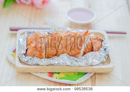 Baked chicken breast on a wood background.