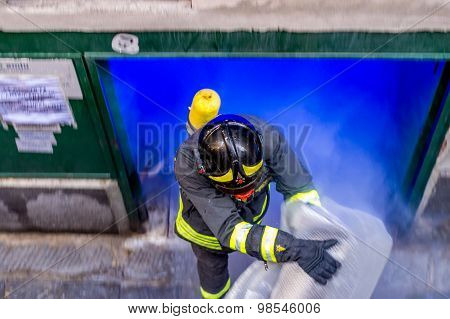 Fireman Taking Out The Burning Plastic Out Of A Storage On Fire