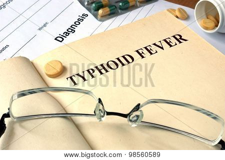 Word  Typhoid Fever on a paper and pills.