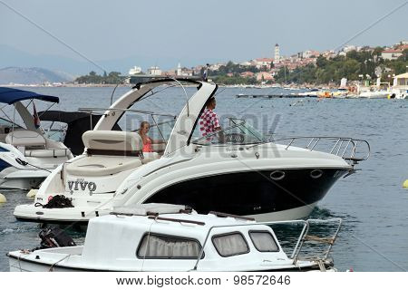 SELCE, CROATIA - JULY 24, 2015: A boy and a girl in the powerboat sailing our of Selce Marina