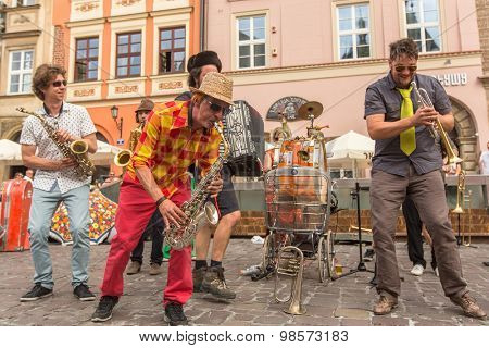 KRAKOW, POLAND - JUL 12, 2015: Participants at the annually (July 9-12) 28th International Festival of Street Theatres - Orchestre International du Vetex (Belgium/France) in the Main Square of Krakow.