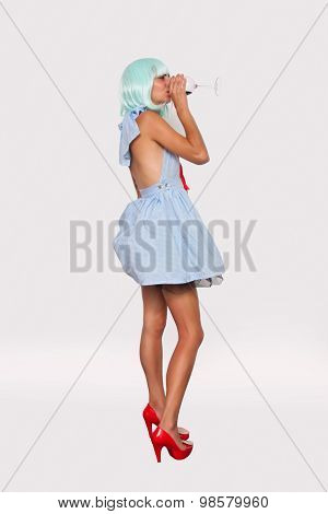 model woman in blue wig drinking glass of wine
