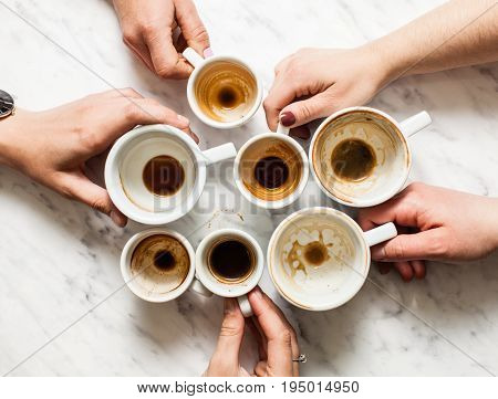 Top view hands holding empty and dirty cups of coffee afterparty