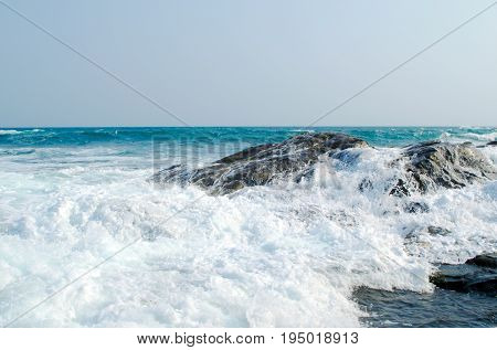 The sea wave is crashed about the shore and rocks