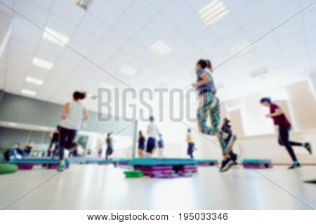 Blurred background of people group of girls playing in yoga and fitness,crossfit in the gym.