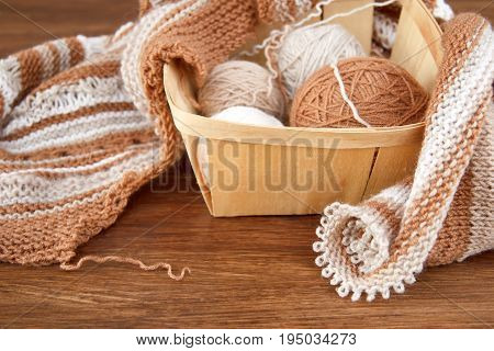 Balls of wool and knitting on the wooden background