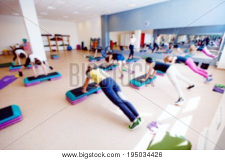 Blurred background of people group of girls playing in yoga and fitness,crossfit in the gym.
