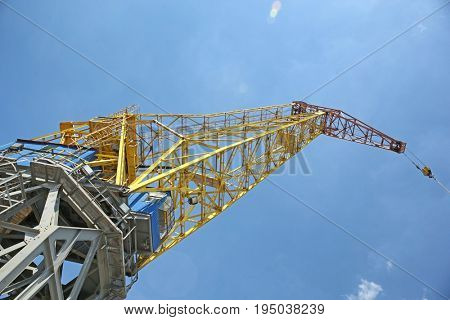 Hoisting crane against blue sky
