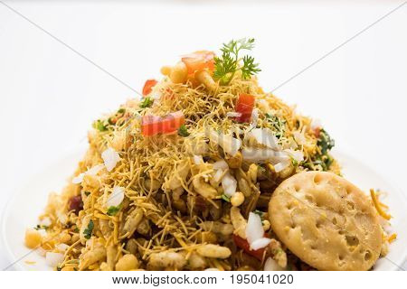 Bhel Puri - Popular Mumbai street food served with coriander and tamarind chutney on white background, selective focus